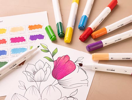 Papier avec motif partiellement coloré et marqueurs autour