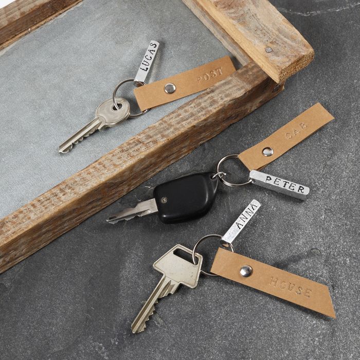 Un porte-clés avec une étiquette métallique embossée et une étiquette en papier simili cuir