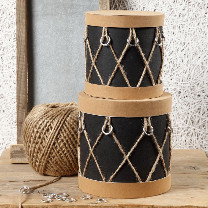 Boîtes en papier mâché décorées comme des tambours avec du papier imitation cuir, des anneaux en plastique et de la ficelle naturelle.