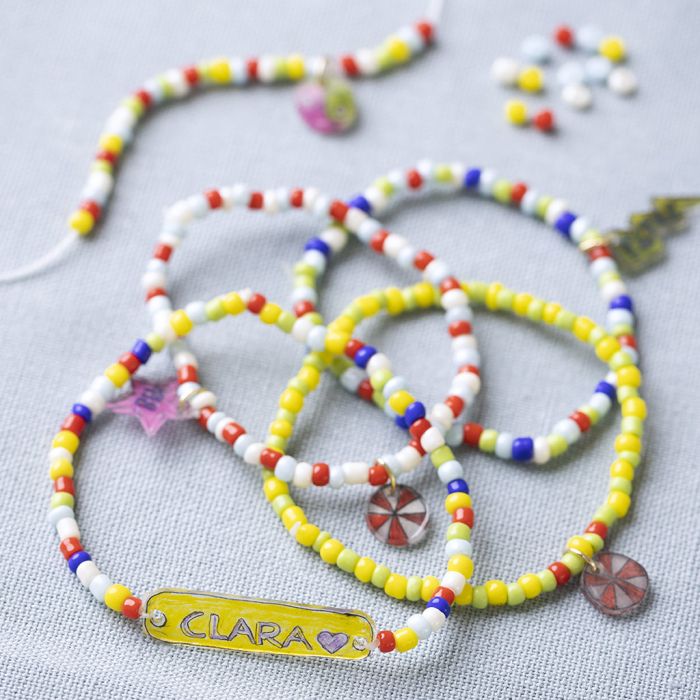 Un bracelet avec des perles de rocaille et un charm en plastique thermorétractable