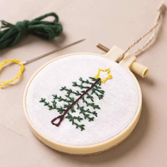 Un cadre de broderie décoré d'un sapin de Noël brodé