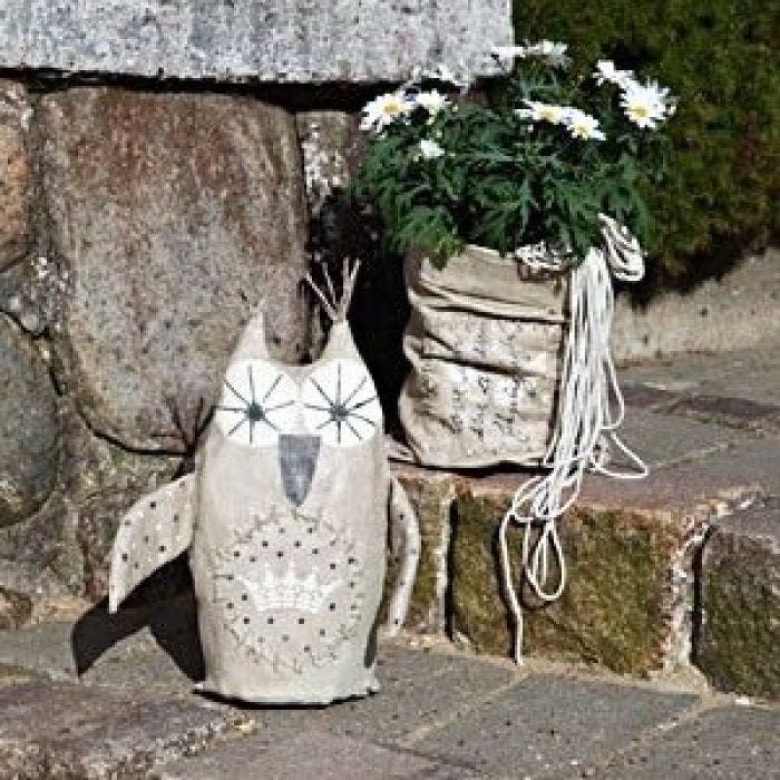 Un hibou décoratif et un vase en forme de sac pour le jardin