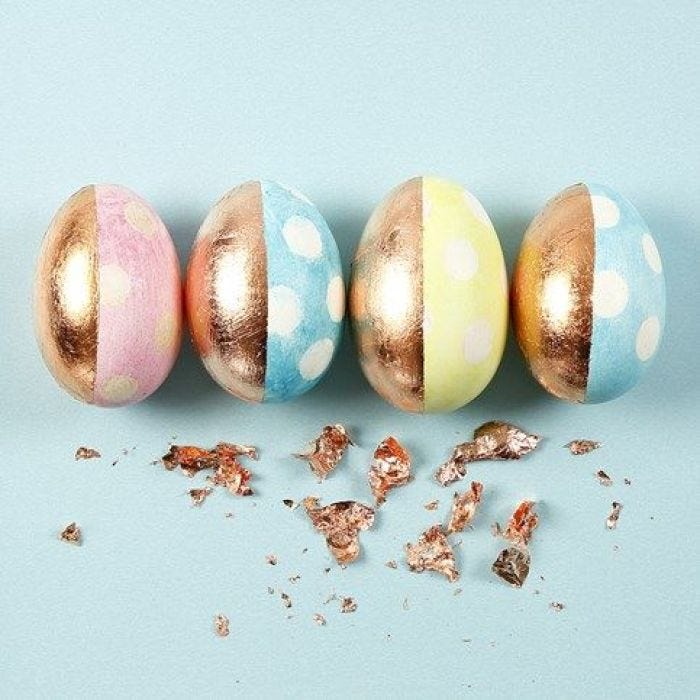 Oeufs couleur pastel avec décorations cuivrées et pois blancs