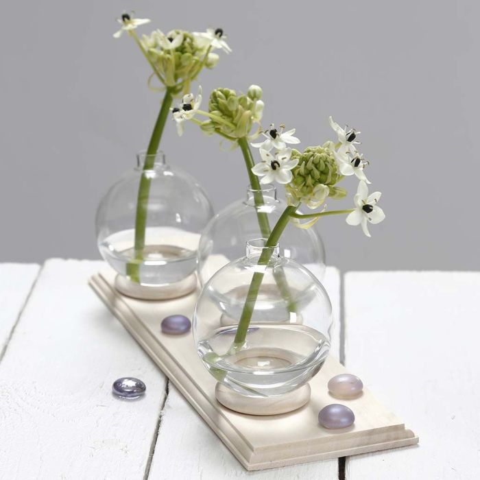 Un petit vase fait à partir d'une boule de verre debout sur une bague de rideau