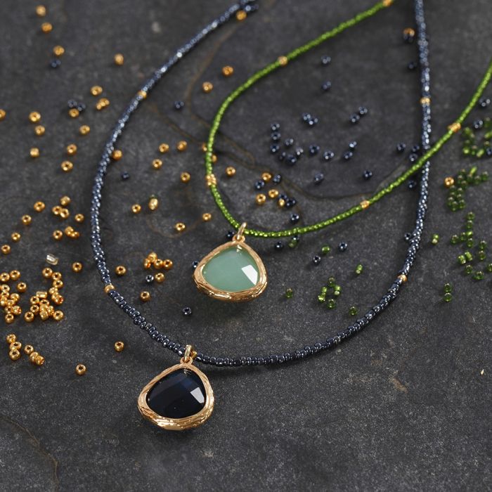 Un collier en perles de rocaille décoré d'une pierre semi-précieuse en pendentif