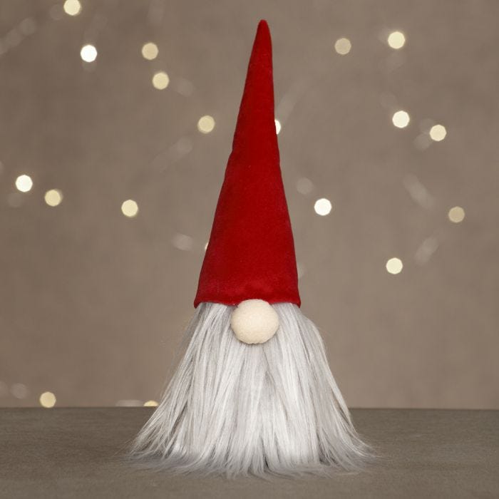 Un lutin avec un gros nez, une longue barbe et un bonnet de lutin en velours
