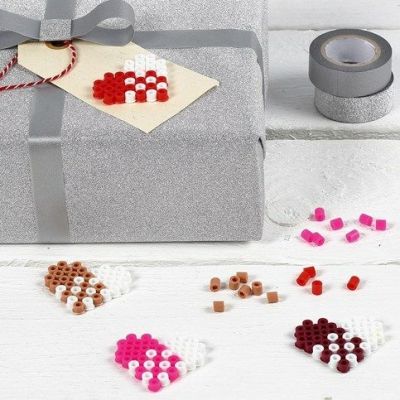 Une étiquette en manille décorée d’un cœur en perles Nabbi