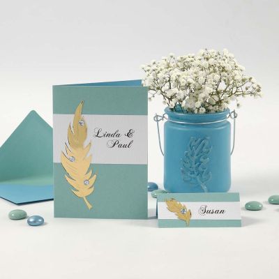 Invitations et marque-places avec des plumes dorées et des pierres de strass