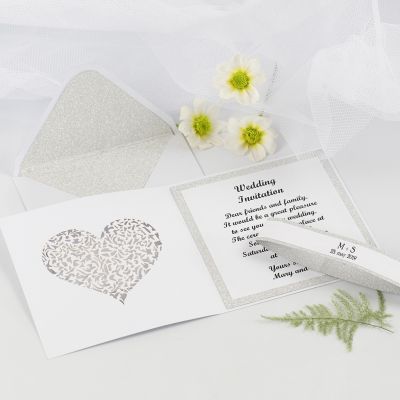 Une invitation de mariage et son enveloppe décorées avec du papier décoratif