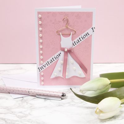 Une invitation pour une fête de confirmation avec une robe sur un cintre