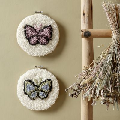 Papillons brodés au point perforé dans un tambour à broder