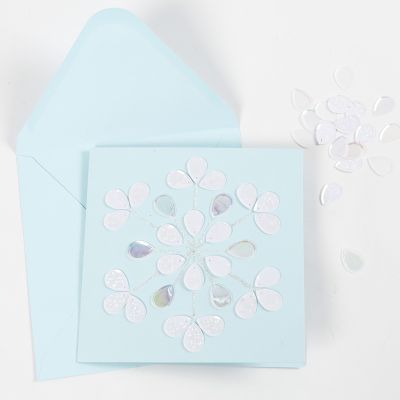 Une carte de vœux décorée avec de la colle pailletée et des sequins