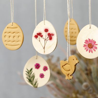 Décorations suspendues en argile auto-durcissante avec des fleurs séchées