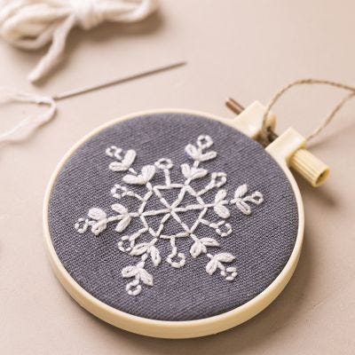 Un cadre à broder décoré d'flocon de neige brodé