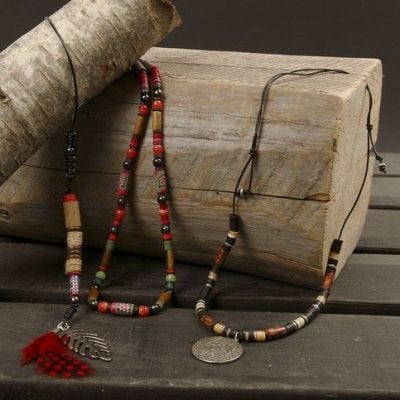Un collier avec des plumes et des perles.