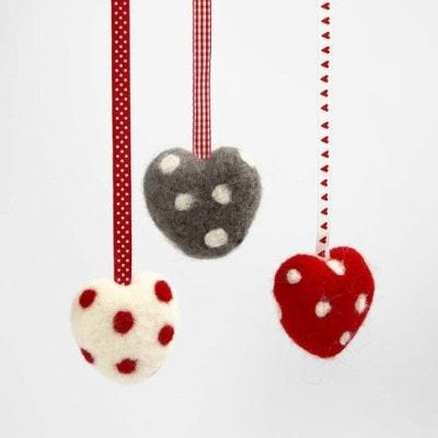Un coeur à pois en laine feutrée et un ruban décoratif