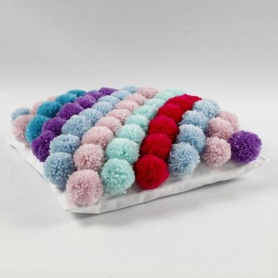 Une housse de coussin faite avec des pompons