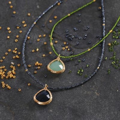 Un collier en perles de rocaille décoré d'une pierre semi-précieuse en pendentif