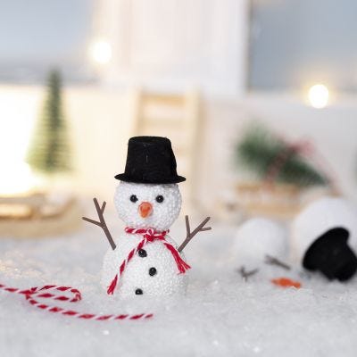 Le lutin fait un bonhomme de neige dehors