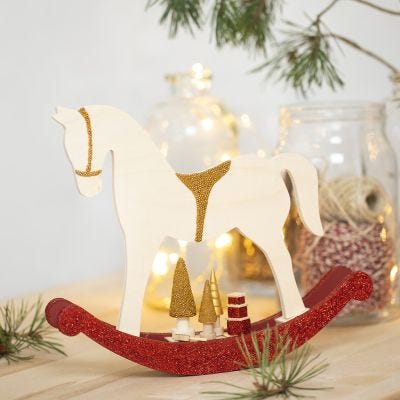 Un cheval à bascule avec de petits accessoires en bois décoré avec de la peinture acrylique