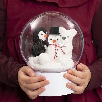 Un boule transparente sur un socle avec un bonhomme de neige