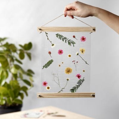 Une décoration à suspendre avec des fleurs séchées et plastifiées placées dans des porte-affiches