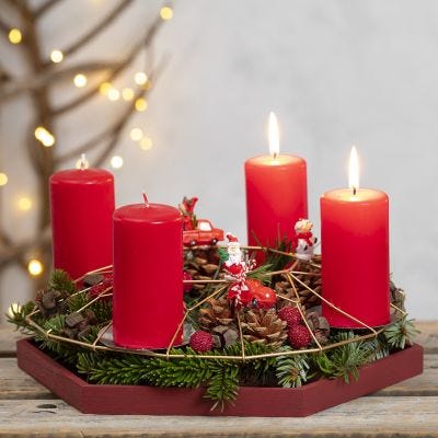 Une couronne de l'Avent faite avec une décoration métallique à suspendre décorée avec des branches d'épinette