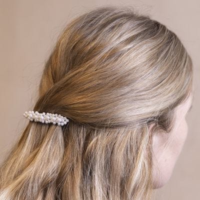 Une barrette décorée avec des fleurs faites en perles de cire