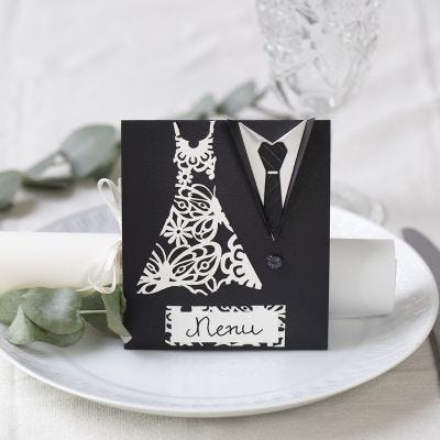 Un menu de mariage décoré avec une robe et un smoking