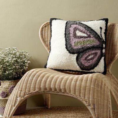 Un coussin décoré d'un papillon tracé au poinçon à broderie