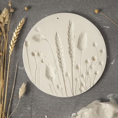 Une assiette en argile autodurcissante avec des empreintes de fleurs séchées