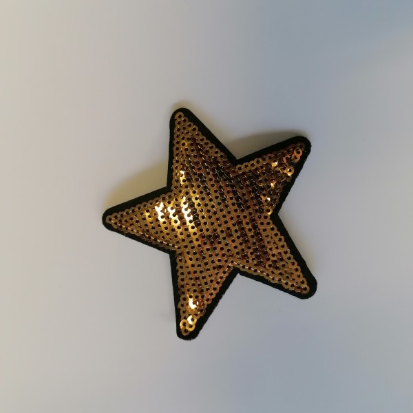 Un thermocollant étoile doré au contour noir - Photo n°1